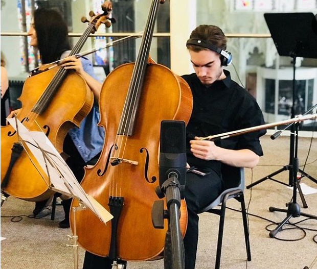 A male cellist in an orchestra